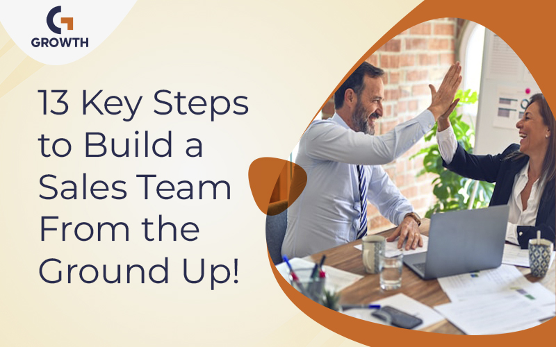 Two coworkers high five during a sales meeting, showing steps to build a strong sales team